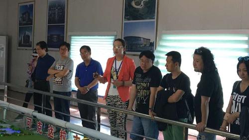中国音协采风团一行在认真听取可克达拉市城市规划介绍