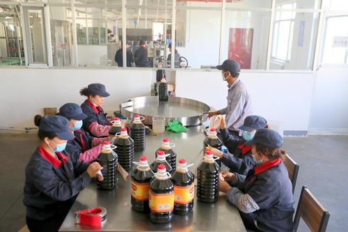 兵团分区新疆恒顺沙林食品有限公司工人正在包装桶装醋