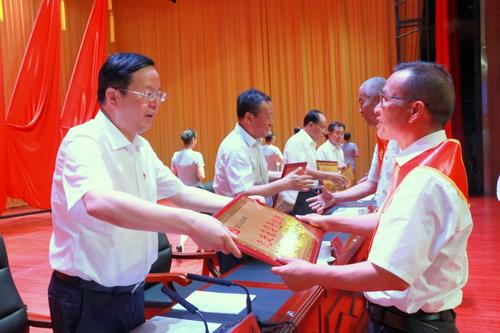 6月30日 , 在师市庆祝建党98周年暨“七一”表彰大会上,师市党委书记、四师政委丁憬为受到表彰的先进基层党组织代表颁奖   杨俊钦　摄