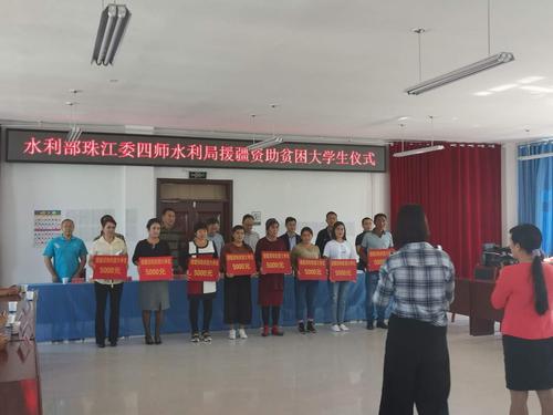 图2为水利部珠江委、兵团水利局、四师水利局、64团参会领导与援疆资助的8名贫困大学生家长合影的一个场景。